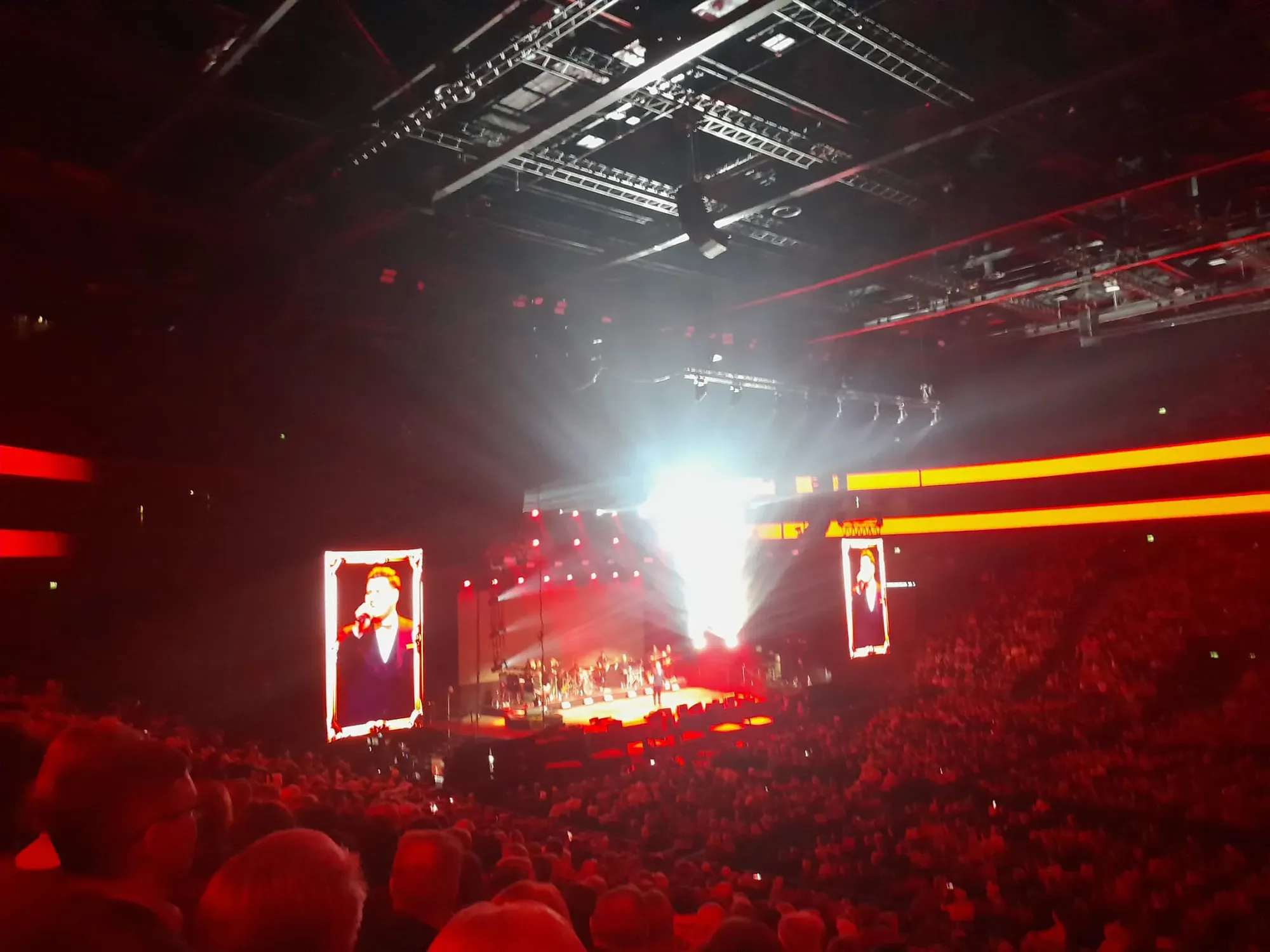 Täysi areena ja valaistu konserttilava punaisessa valossa